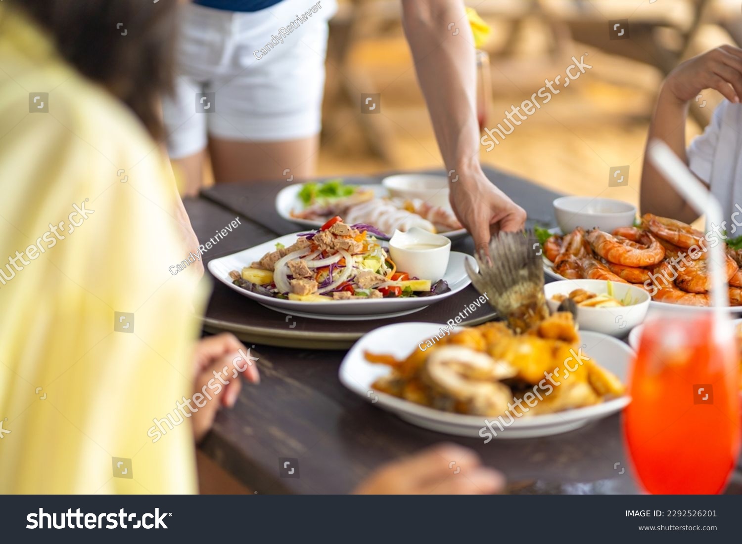 Happy Asian family couple and little kids travel ocean on summer holiday vacation. Waitress serving food and drink to customers on the table at beach restaurant at tropical island beach in sunny day. #2292526201