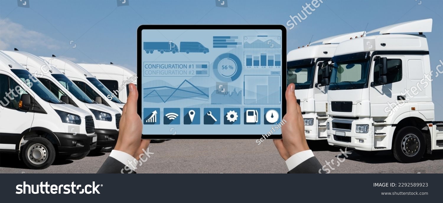 Manager with a digital tablet on the background of vans and trucks. Fleet management #2292589923