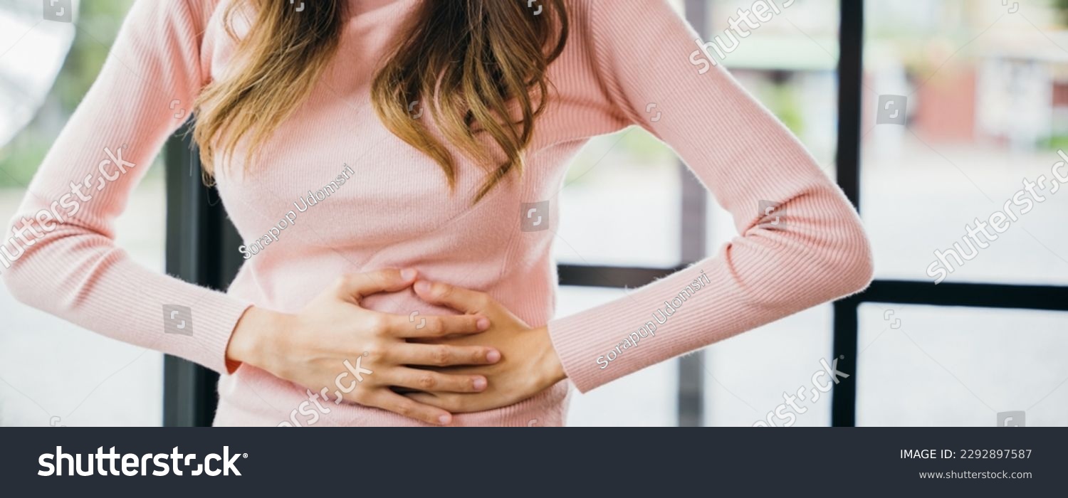 Sick woman unhappy having stomach ache at home, Asian young female suffers from stomachache after eating spoiled food, Abdominal pain from menstrual cramps #2292897587