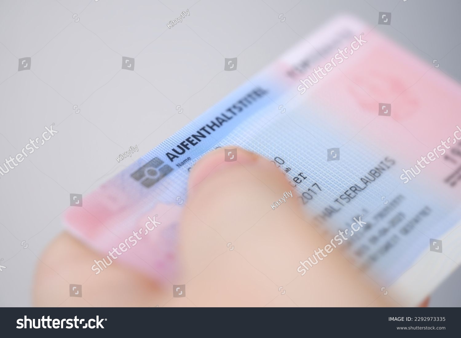 identity card, residence permit, personal document in female hand close-up with shallow depth of field, electronic communication in Europe, migration law, passport control at border, foreign travel #2292973335