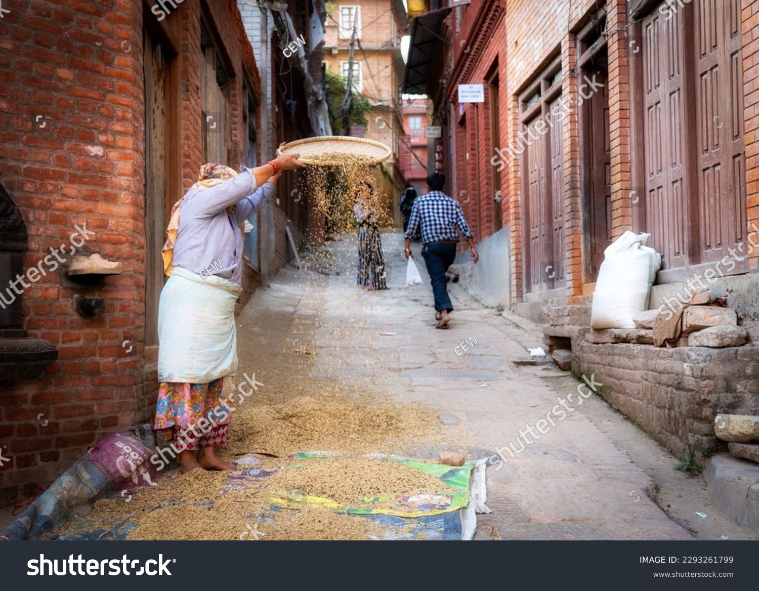 A woman sifting the chaff out of the rice in the old city of Bhaktapur Nepal. #2293261799
