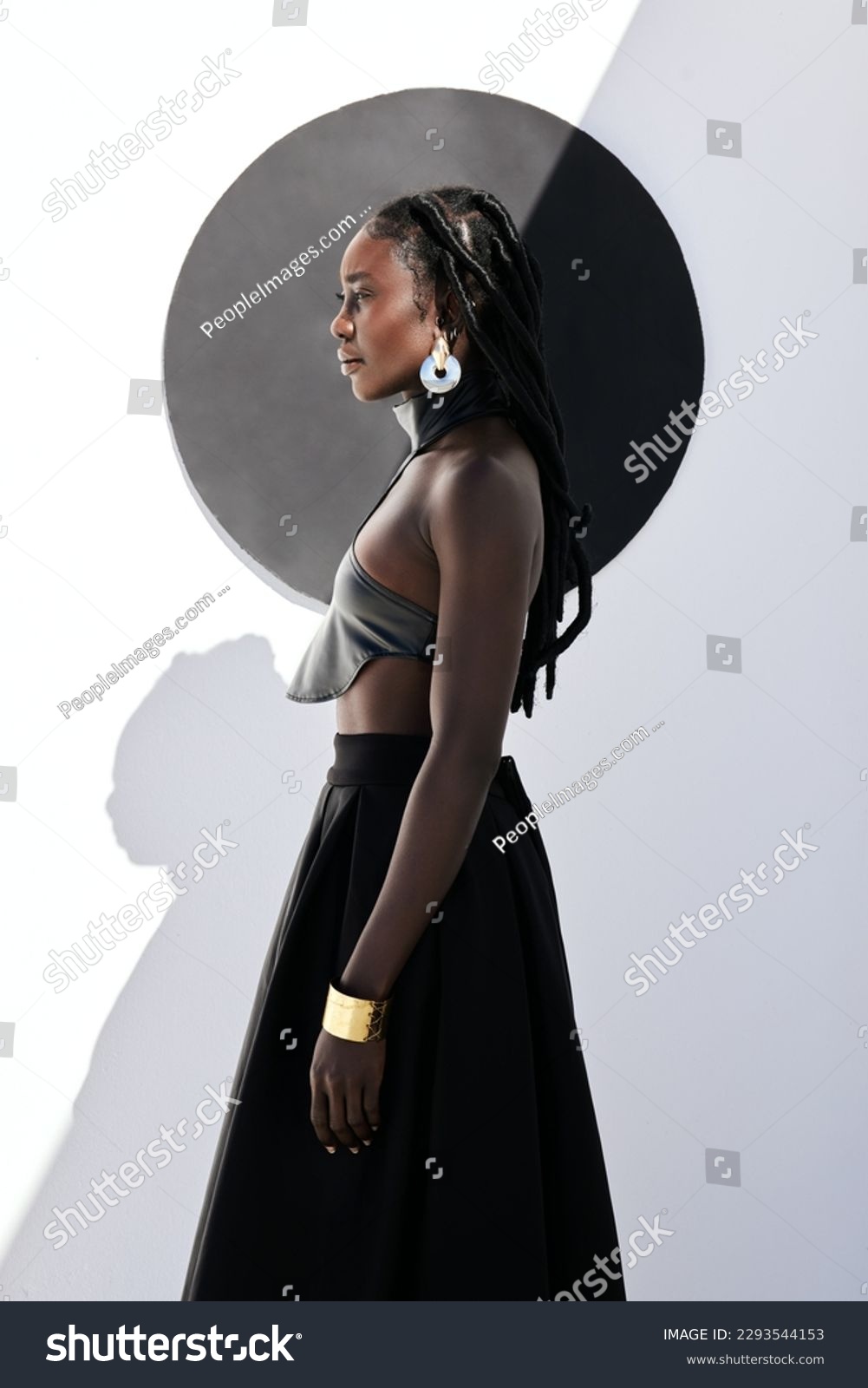 Fierce and fabulous. Shot of an attractive young woman posing in a black outfit against a wall with a circle on it. #2293544153