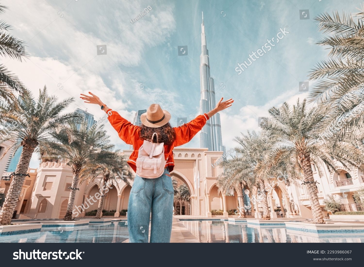 From behind, you can see the traveler girl arms spread wide as she take in the incredible view of the Burj Khalifa and the Dubai skyline. #2293986067