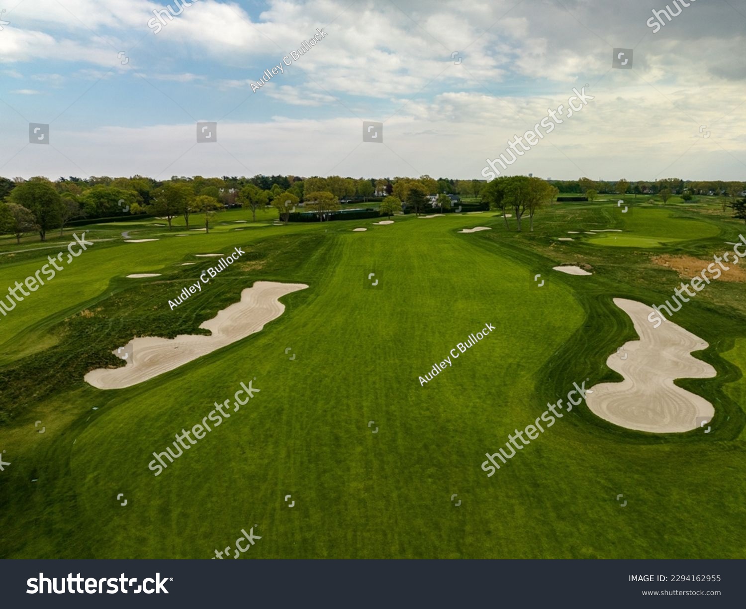 An aerial view over a pristine golf course on Long Island, New York during a beautiful day with blue skies and white clouds. No one was playing golf today. #2294162955