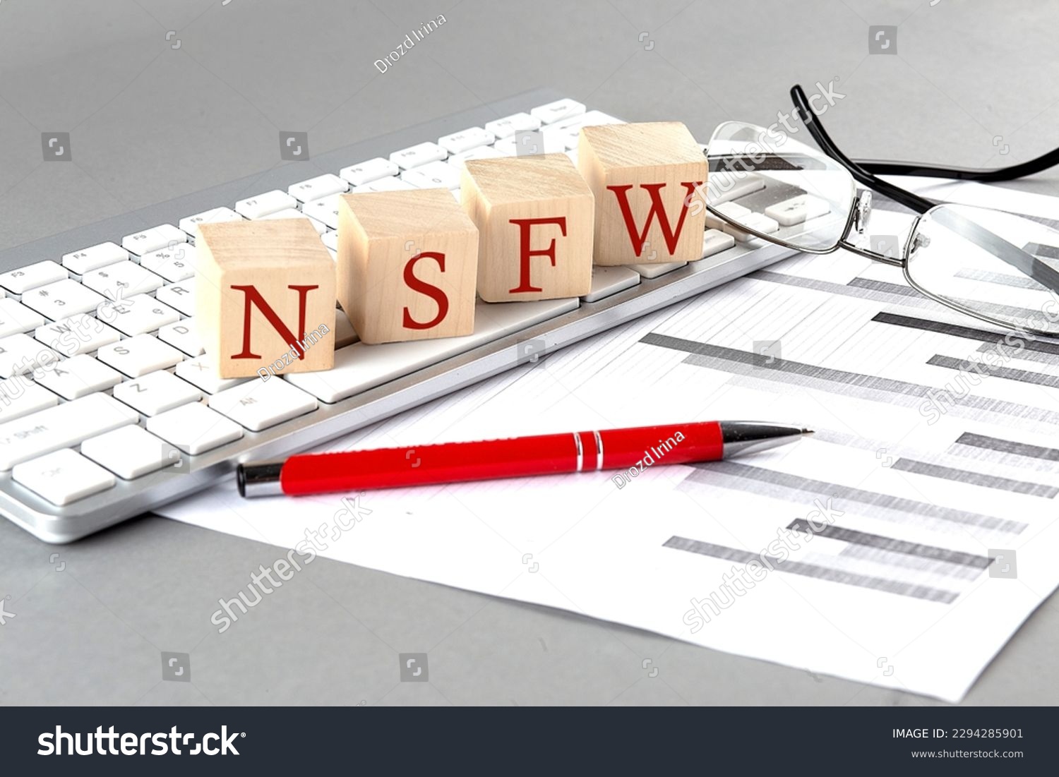 NSFW written on wooden cube on the keyboard with chart on grey background #2294285901