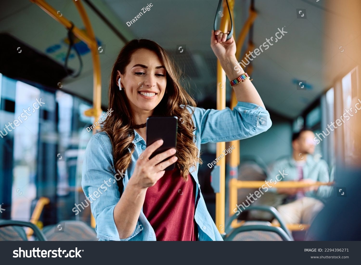 Happy woman text messaging on mobile phone while riding in a bus.  #2294396271