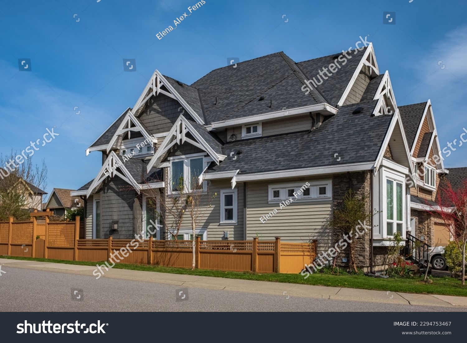 Real Estate Exterior Front House on a sunny day. Big custom made luxury house with front yard in spring. Roof shingles on top of the house. Dark asphalt tiles on the roof, black shingles, roof tile #2294753467