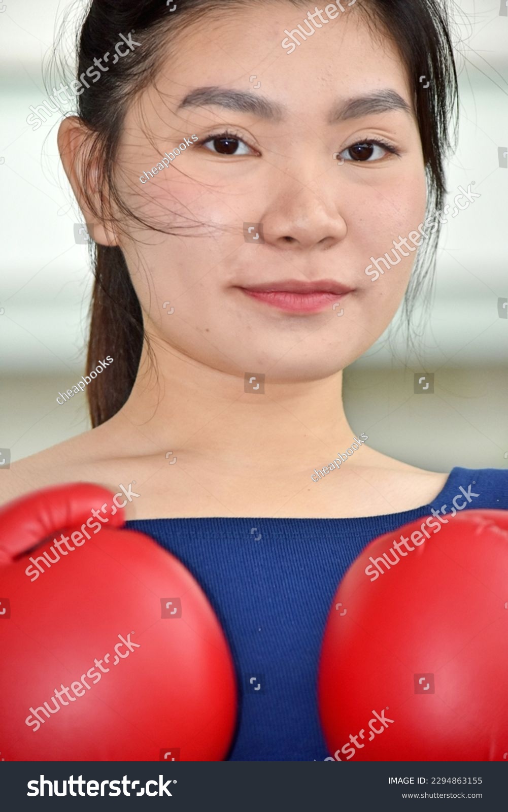 Unemotional Fitness Female Athlete Wearing Boxing Gloves #2294863155