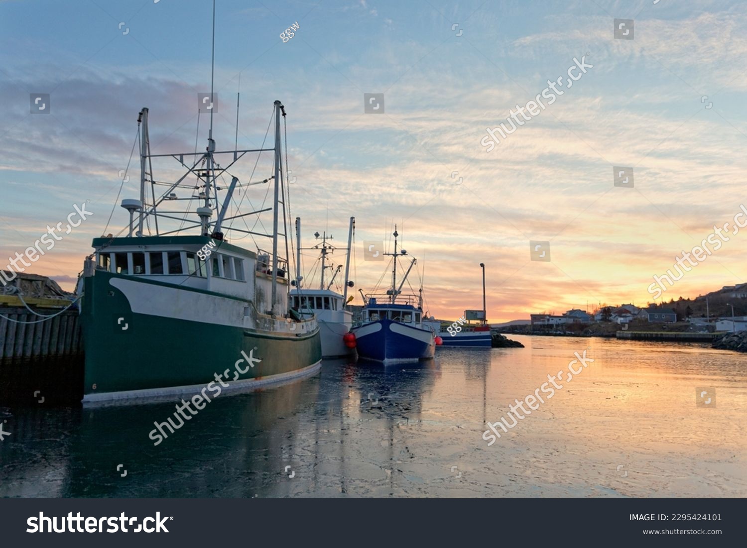 Fishing boats moored at the dock at sunset during the winter, Port de Grave, Newfoundland and Labrador, Canada. #2295424101