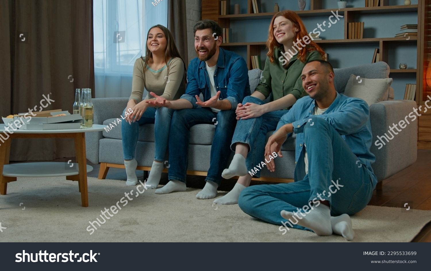 Four diverse ethnicity friends watch television at home cinema people spectators watching smart tv channel comedy show serial movie multiracial african american caucasian women men laughing enjoy film #2295533699
