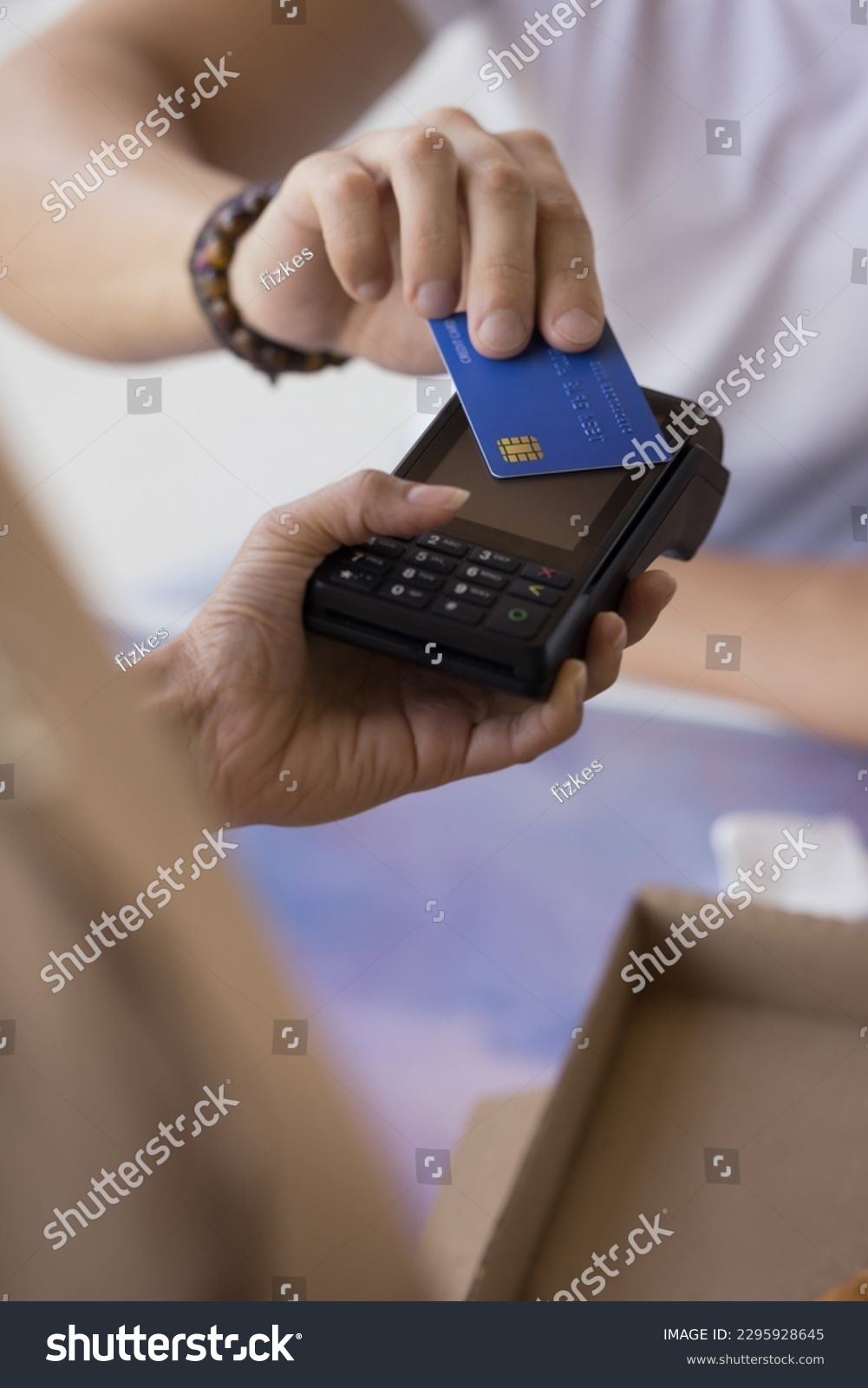 Man purchasing goods, commercial services, paying bills, makes cashless contactless quick payment for order applies credit card on POS terminal cashier machine, close up vertical view. NFC technology #2295928645
