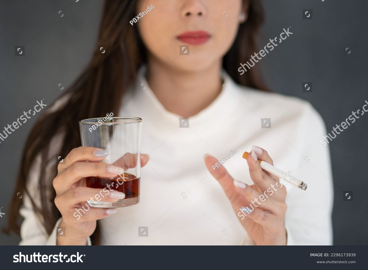 Asian woman hand drinking glass of alcohol and smoking cigarette. #2296173939