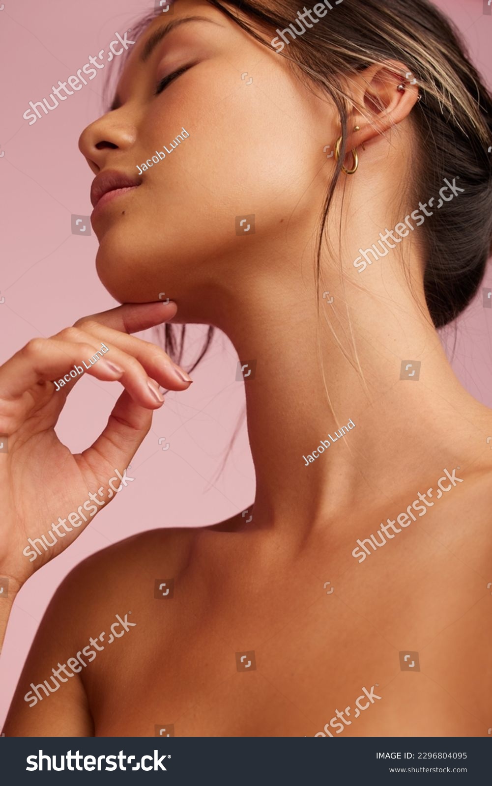 Close-up of a beautiful woman with clean and clear skin. Asian female model with hand on chin and eyes closed. #2296804095