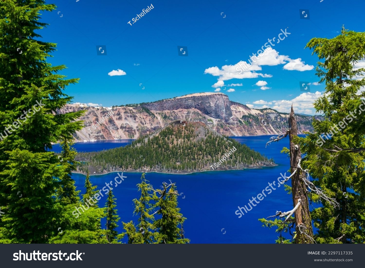 Beautiful Crater Lake National Park with late season snow still lingering into early summer. Bright blue lake with reflections #2297117335