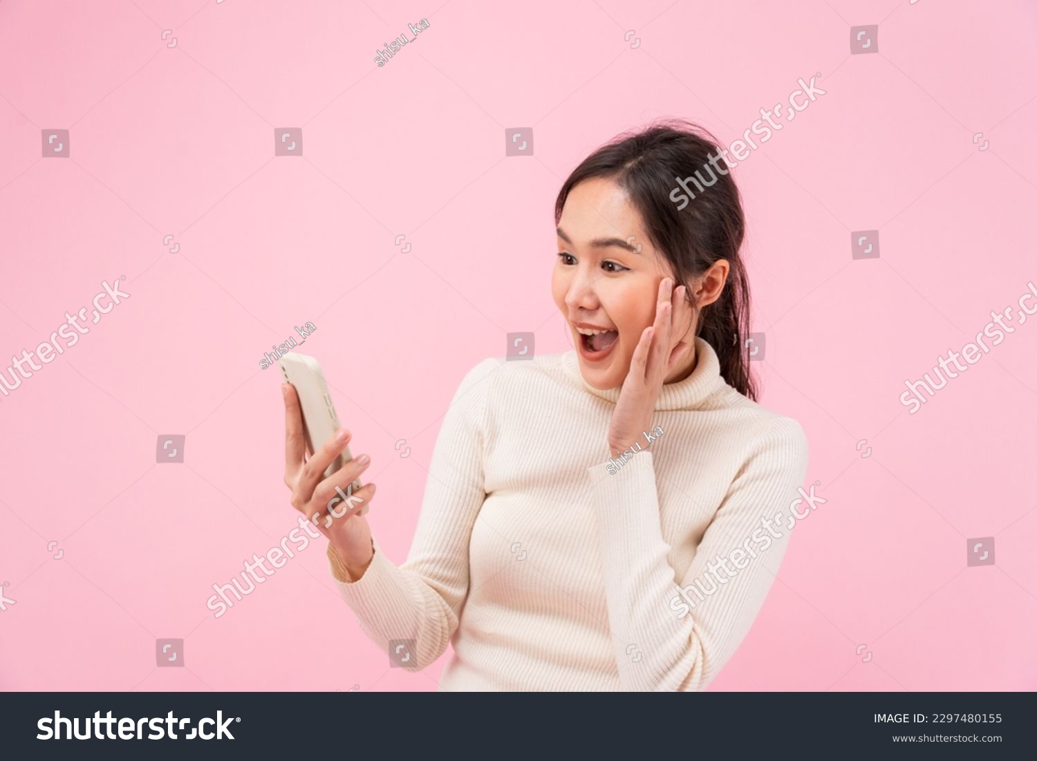 Asian beautiful woman exited surprise face expression . female feels shocked. exciting smile and happy adorable rejoices. Very enjoy and fun relax time. wow, girl holding smartphone. Smile.
 #2297480155