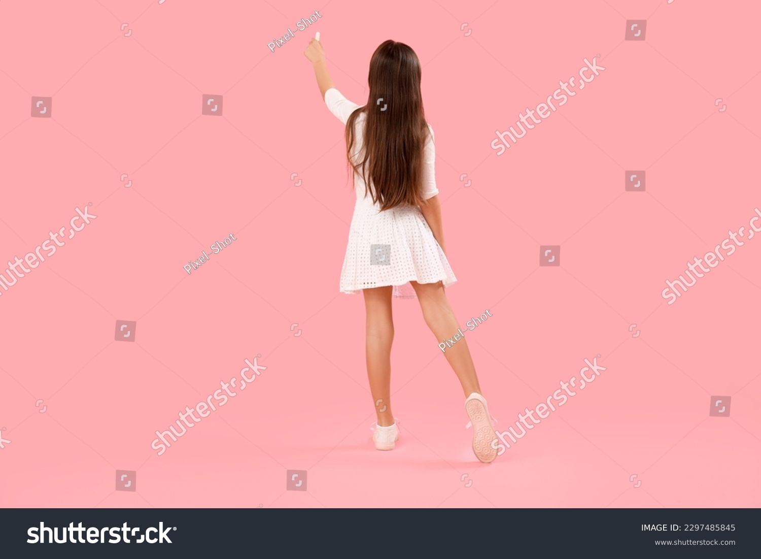 Little girl drawing with chalk piece on pink background, back view. Children's Day celebration #2297485845