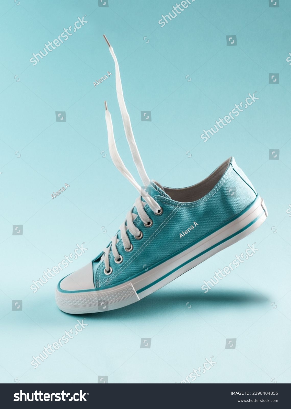 A classic blue sneaker floats in the air on a blue background. #2298404855