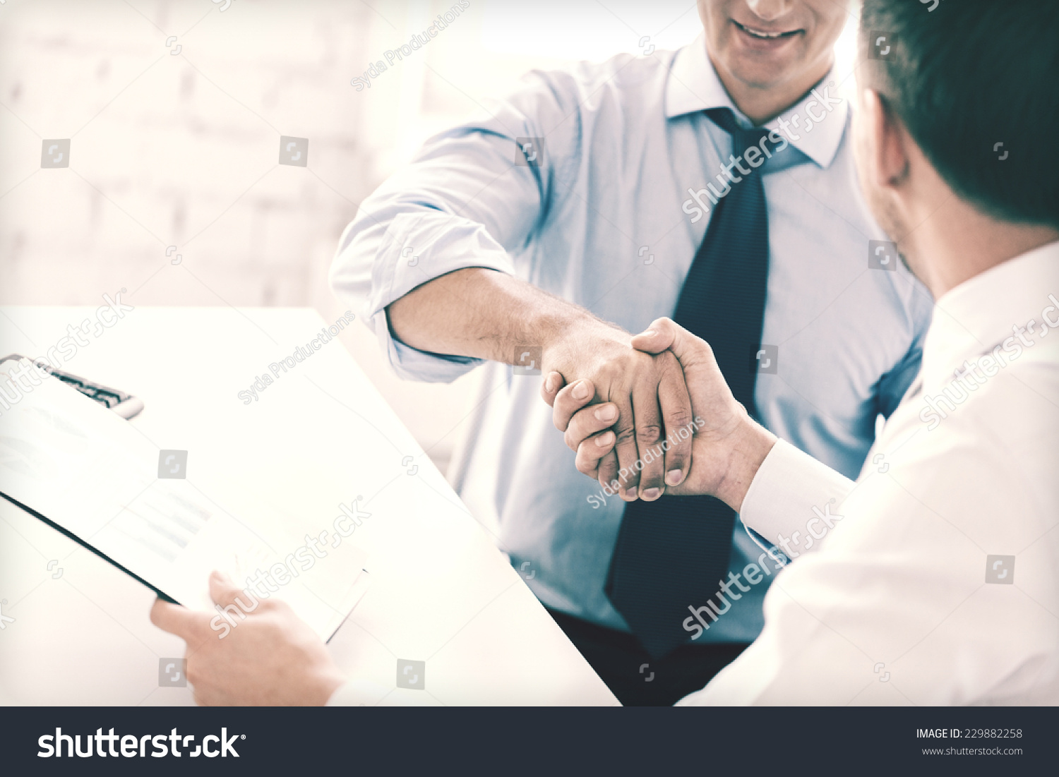 businesss and office concept - two businessmen shaking hands in office #229882258
