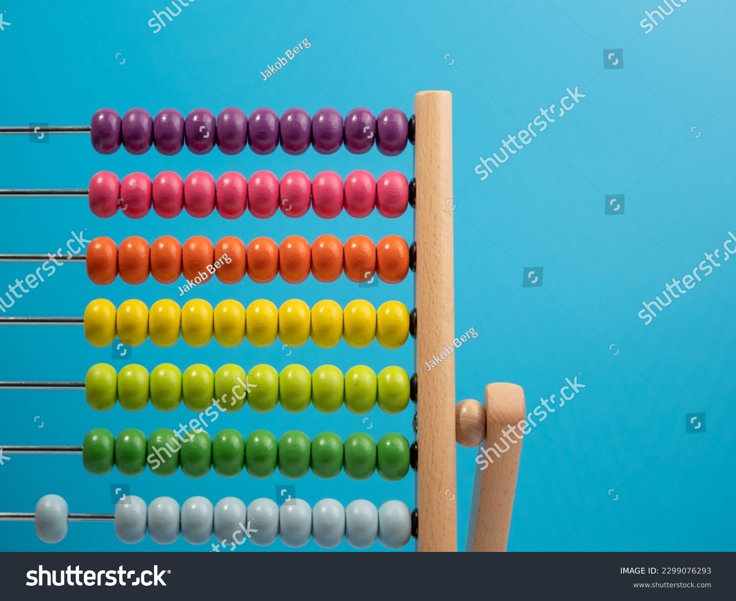 Wooden abacus on a blue background, Wooden abacus for children. Wooden abacus close-up. #2299076293