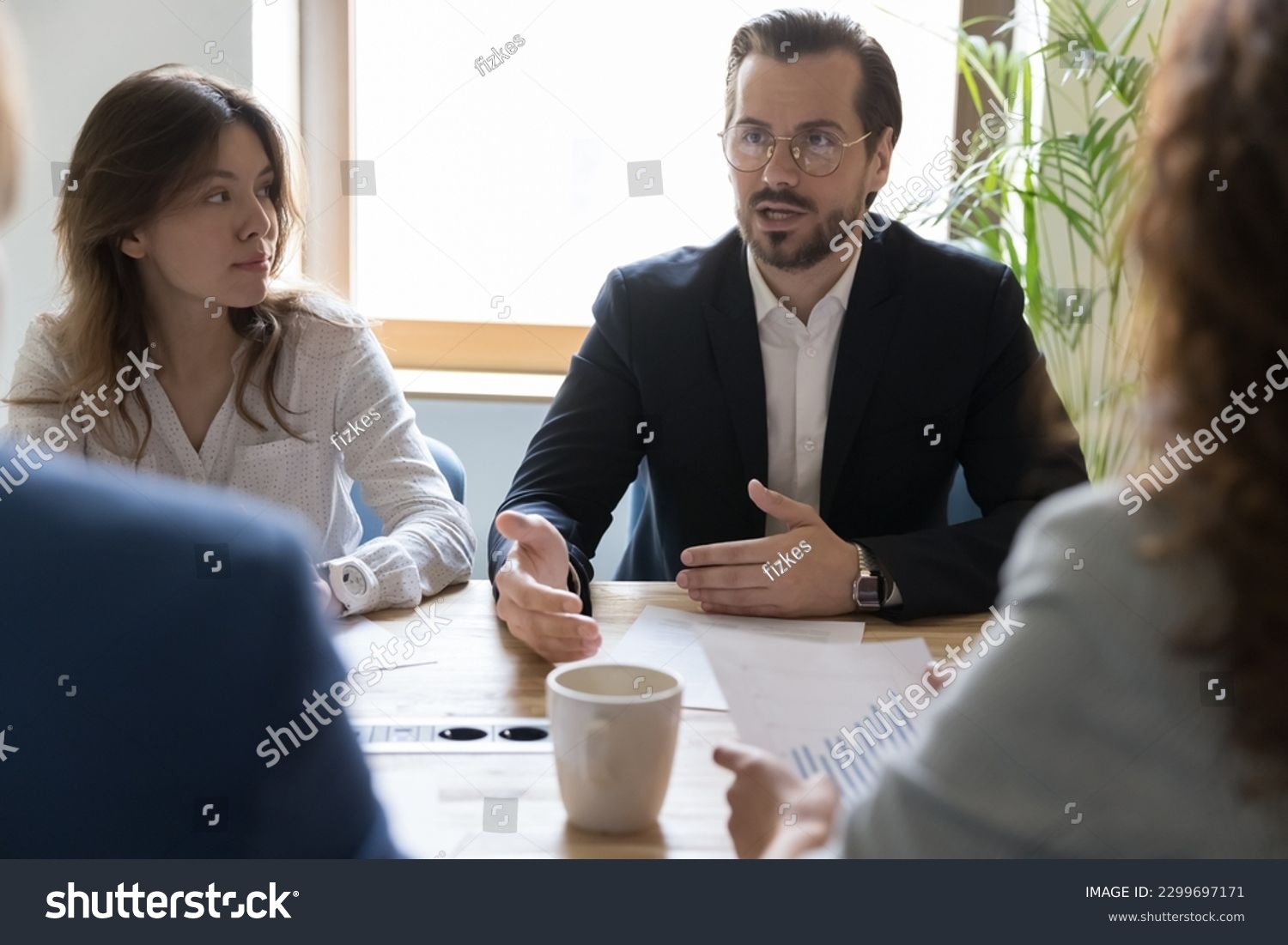 Department brainstorming in office board room, staff led by male CEO discussing new project, sharing ideas thoughts and sales statistics, provide information to shareholders engaged in formal meeting #2299697171