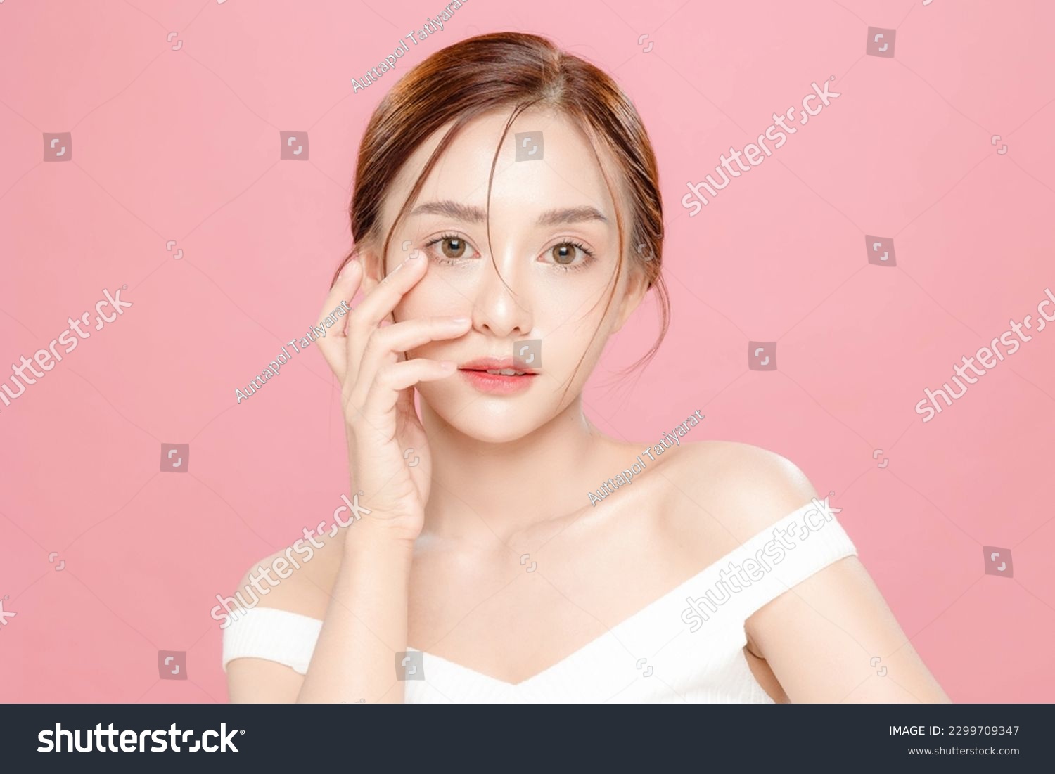 Young Asian beauty woman pulled back hair with korean makeup style touch her face and perfect skin on isolated pink background. Facial treatment, Cosmetology, plastic surgery. #2299709347