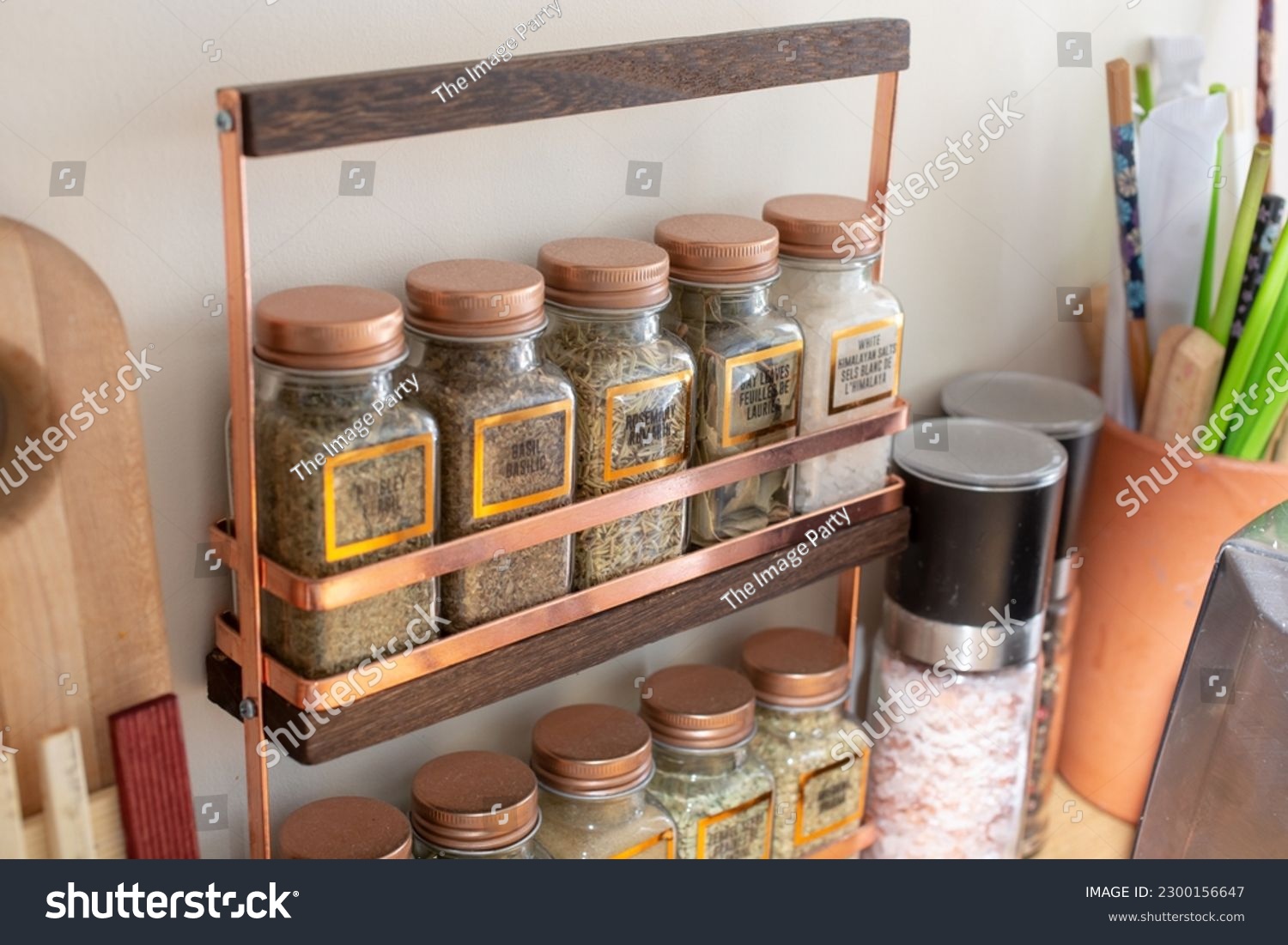 A view of a counter spice rack, seen in a home kitchen setting. #2300156647