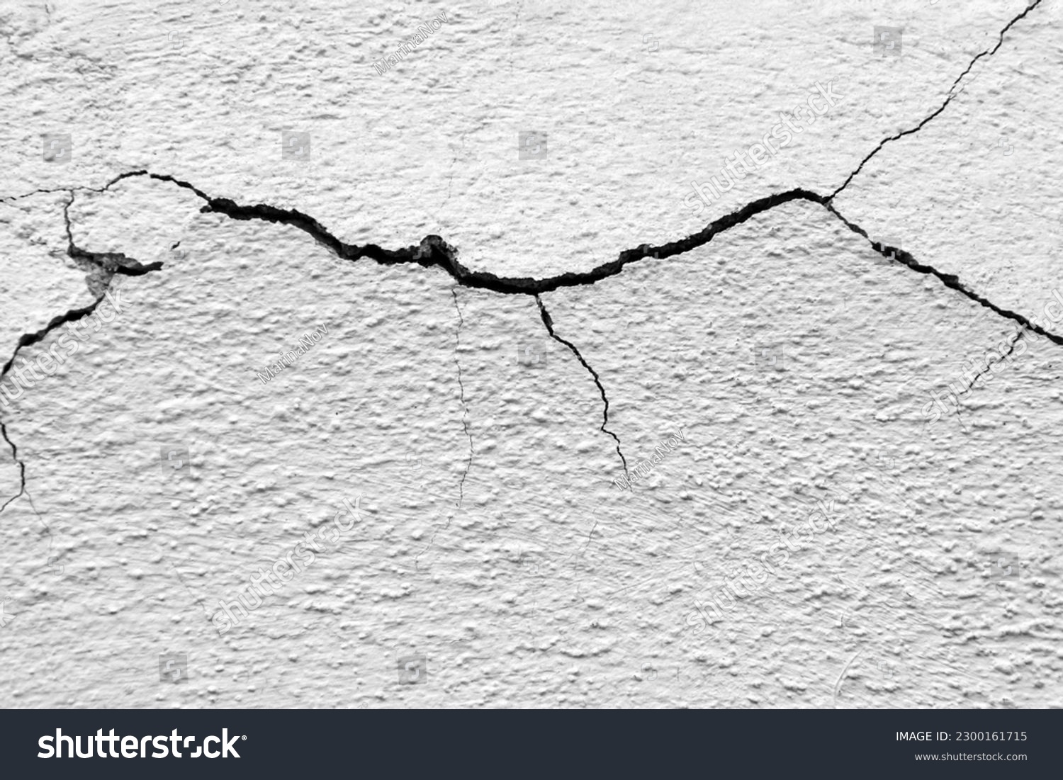 Big winding horizontal crack on old white plastering wall. Copy space. Selective focus. #2300161715