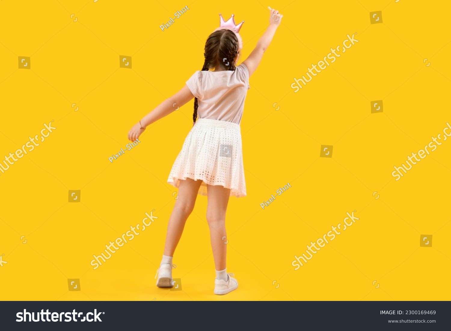 Little girl in crown with chalk piece on yellow background, back view. Children's Day celebration #2300169469