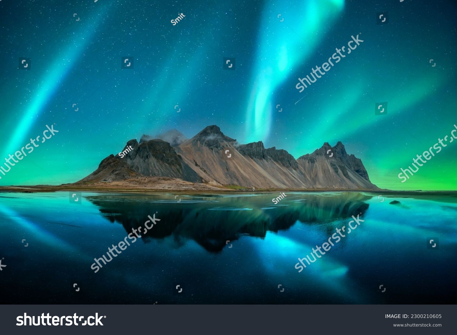 Aurora borealis Northern lights over famous Stokksnes mountains on Vestrahorn cape. Reflection in the clear water on the epic skies background, Iceland. Landscape photography #2300210605