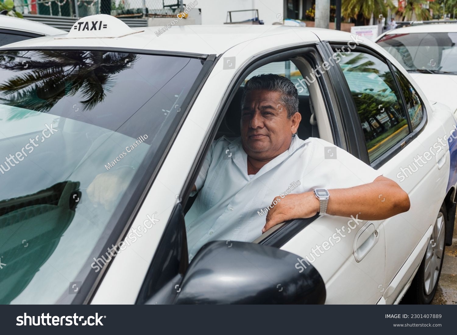 portrait of latin taxi driver senior man with car on background at city street in Mexico in Latin America, Hispanic adult people #2301407889