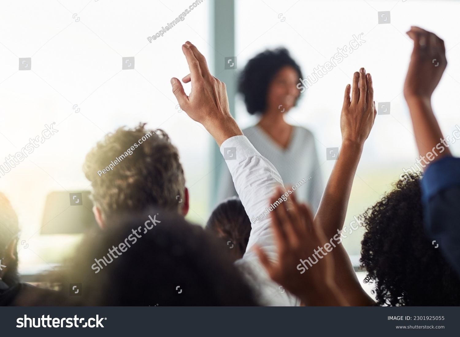 Back, business people and hands raised for questions at conference, seminar or meeting. Group, audience and hand up for question, asking or answer, crowd vote and training at workshop presentation. #2301925055