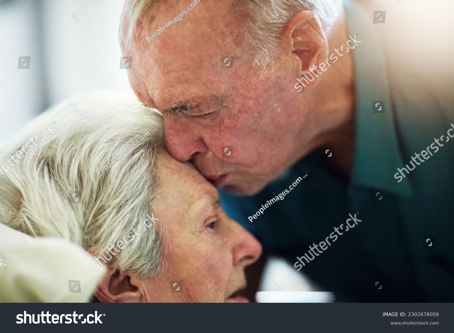 Senior, kiss and couple in hospital for healthcare, visiting sick patient and hope for recovery. Clinic, elderly man and woman kissing on forehead with love, care and empathy, kindness and comfort. #2302678059