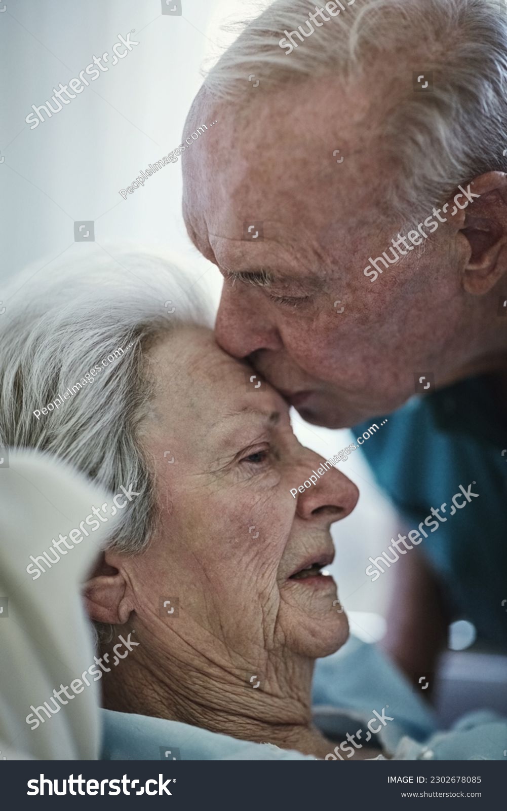 Senior, kiss and couple in hospital for love, visiting sick cancer patient and hope for recovery. Clinic, elderly man and woman kissing on forehead for empathy, kindness and support for healthcare. #2302678085