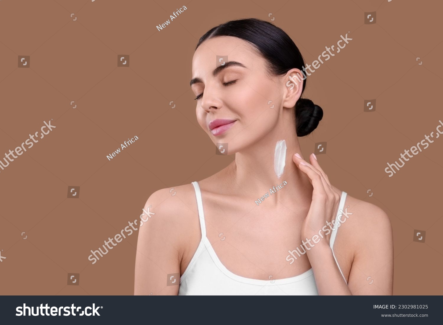 Beautiful woman with smear of body cream on her neck against light brown background. Space for text #2302981025