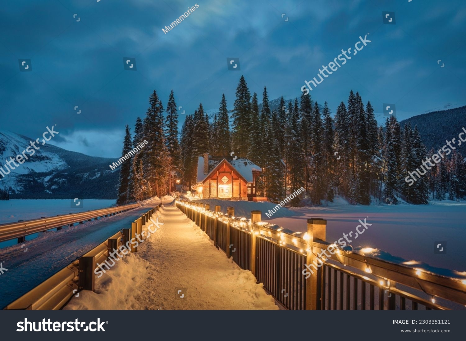 Beautiful view of Emerald Lake with wooden lodge glowing in snowy pine forest on winter at Yoho national park, Alberta, Canada #2303351121