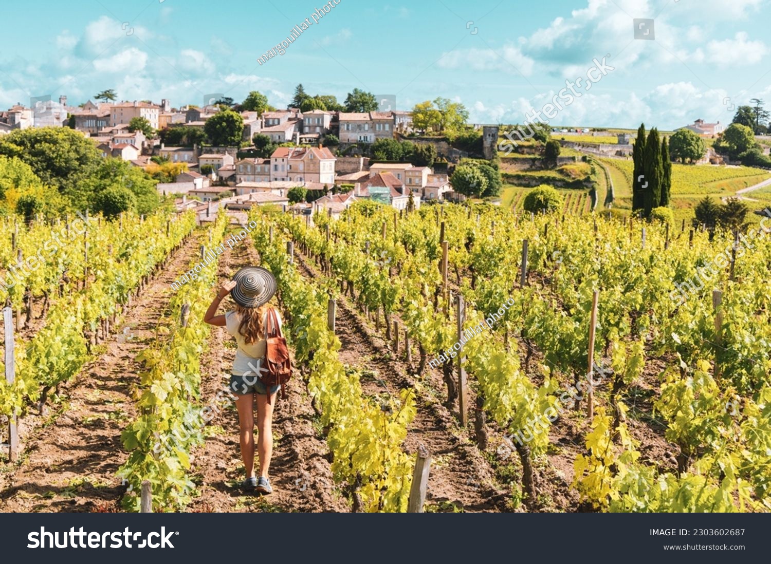 Woman enjoying Saint Emilion village in green vineyard, Bordeaux in France #2303602687