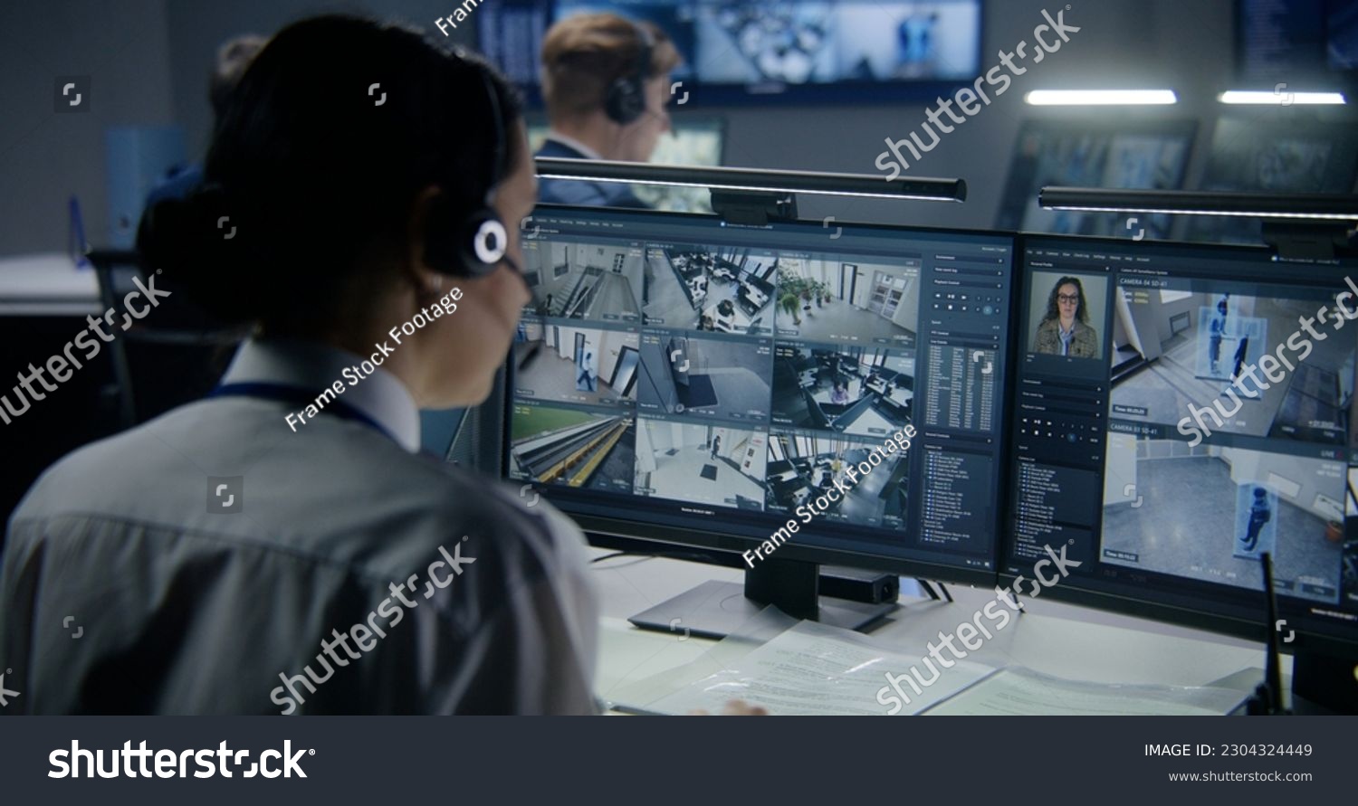 Diverse employees work in security control center, watch CCTV cameras with AI face scanning. Female operator uses PC. Computer monitors and big digital screens with surveillance cameras video footage. #2304324449