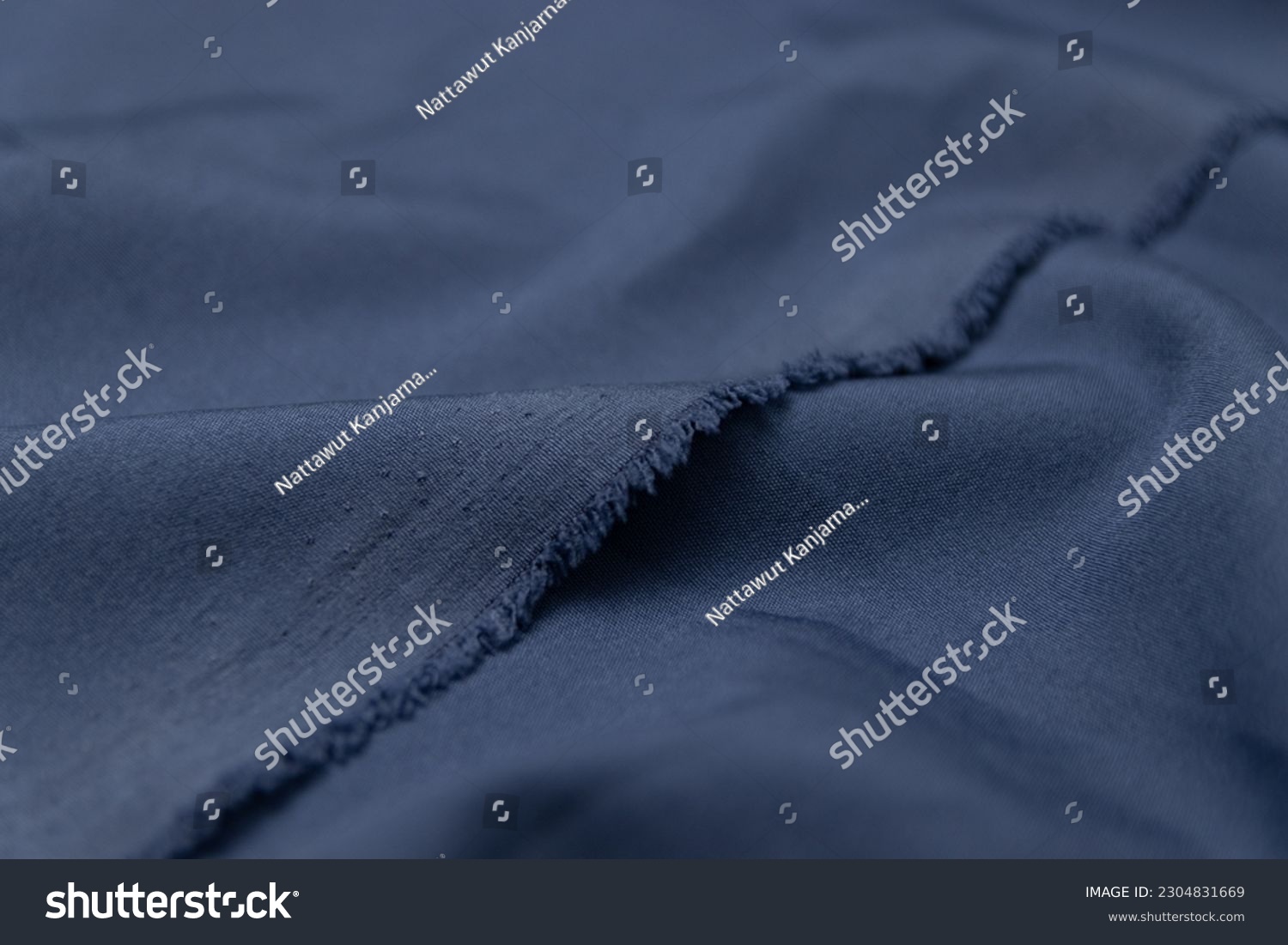 Folded indigo blue colored fabric texture background. This fabric is made of polyester and spandex. #2304831669