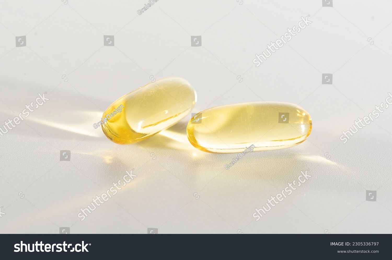 Fish Oil Omega 3 on white background, vitamin D yellow supplement gel capsules, macro shot #2305336797