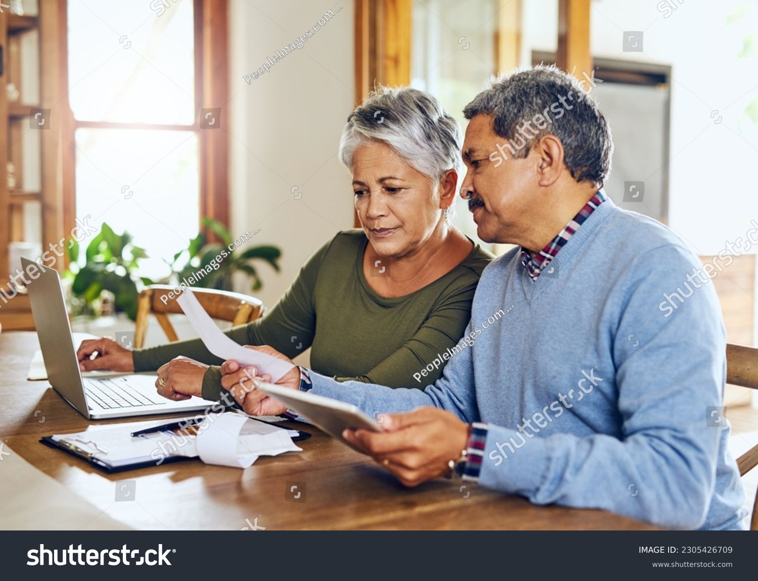 Senior couple, budget planning and health insurance checklist with computer at home. Documents, pension and elderly people with financial, tax and debt form in a house with bills and pc admin #2305426709