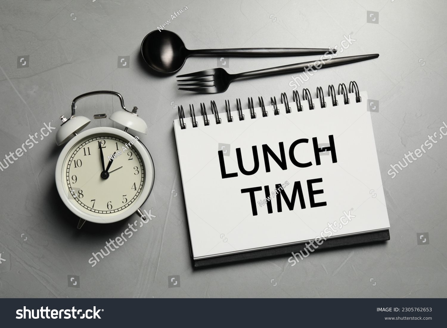 Business lunch. Notebook with phrase Lunch Time, cutlery and alarm clock on light gray table, flat lay #2305762653