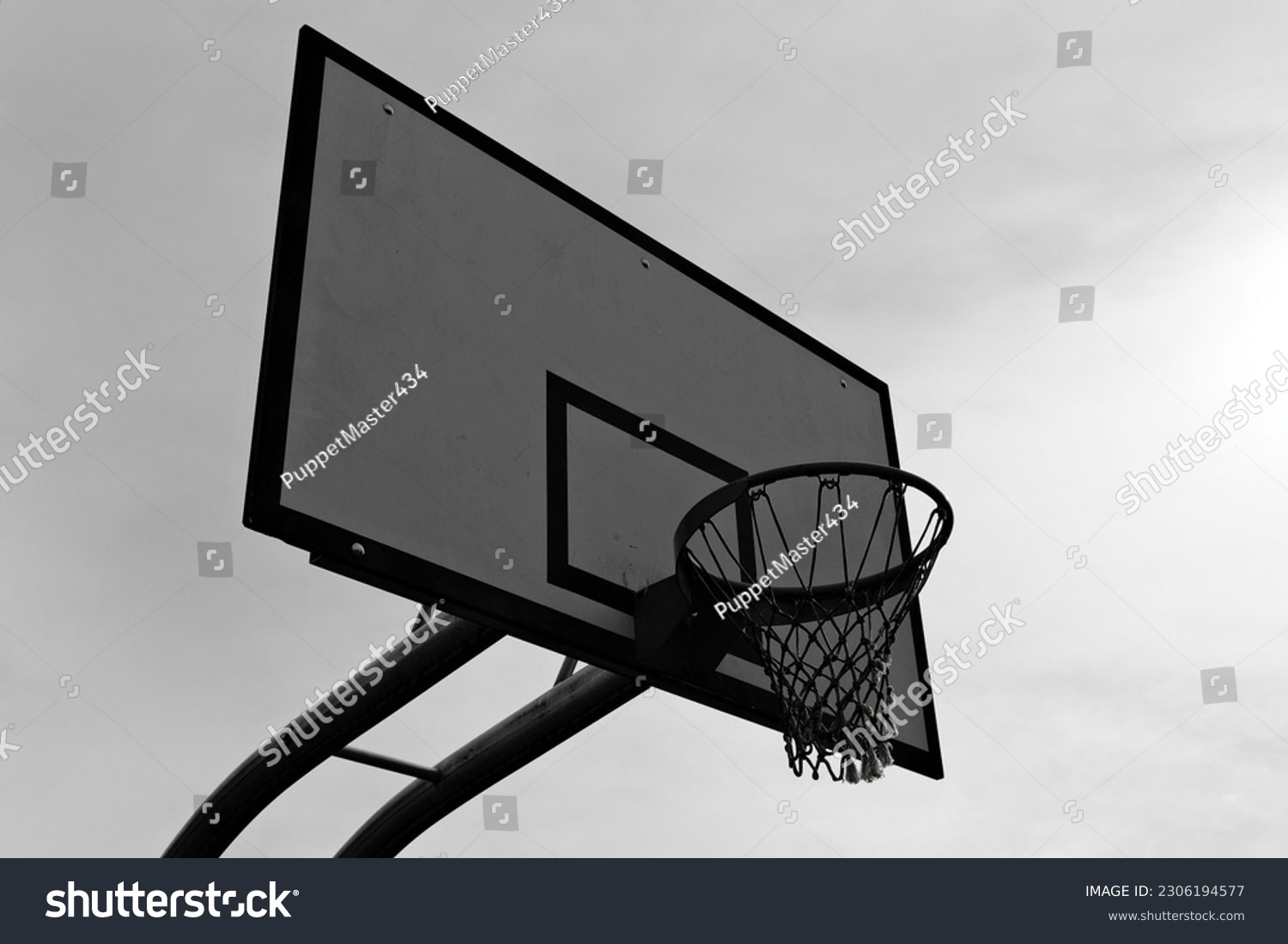 A basketball hoop, mounted on a backboard, providing a target for players to shoot the ball through, adding excitement and challenge to the game. #2306194577