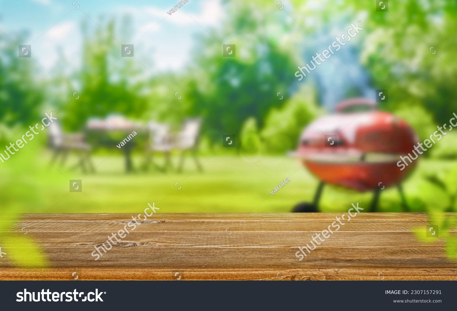 summer time in backyard garden with grill BBQ, wooden table, blurred background #2307157291