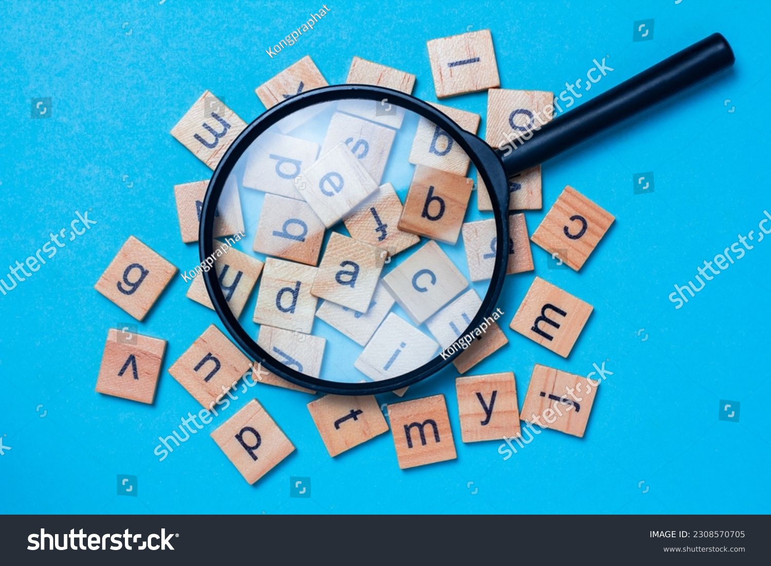 English alphabet made of square wooden tiles with the English alphabet scattered on blue background. The concept of thinking development, grammar. #2308570705
