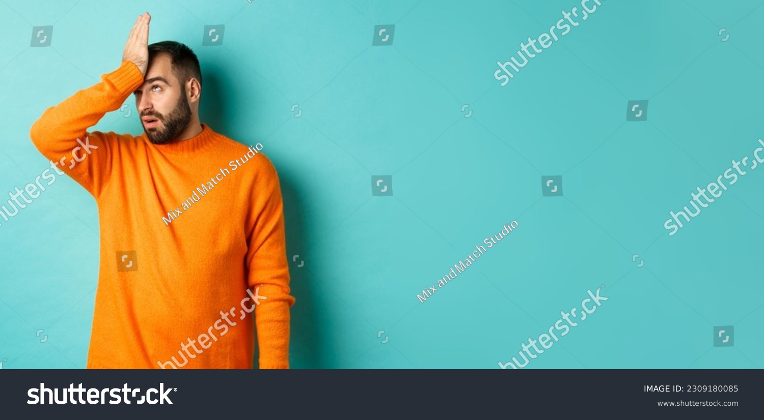 Annoyed man roll eyes and making facepalm, standing over turquoise background. #2309180085