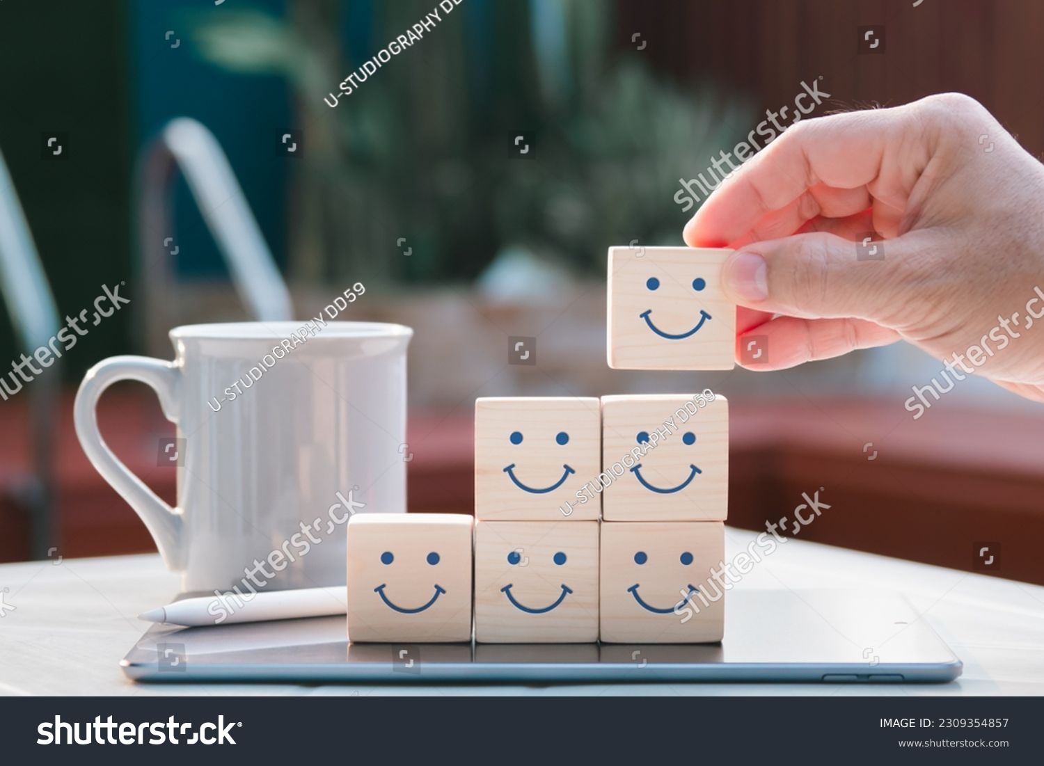 Concept of mental and emotional well-being; a happy face is displayed on the face of a wooden block cube to represent a good outlook. #2309354857