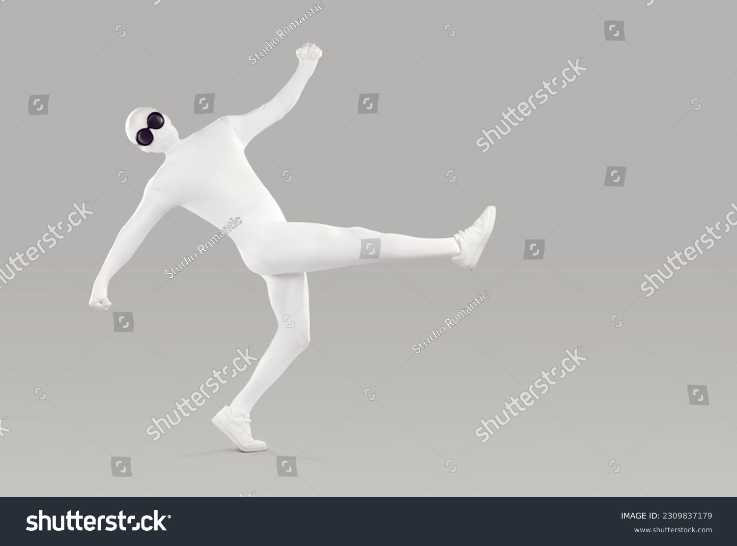 Full length portrait of a funny, happy man in a white, faceless, skintight, spandex bodysuit costume disguise and black, round sunglasses walking or dancing isolated on a grey color background #2309837179