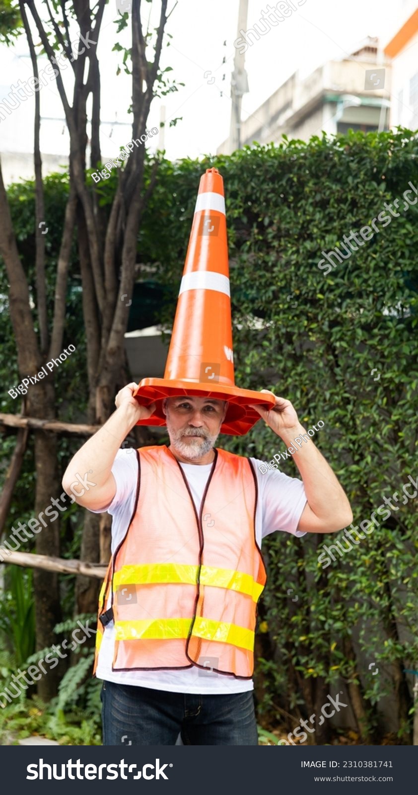 Engineer senior man with traffic cone on head. funny under construction #2310381741