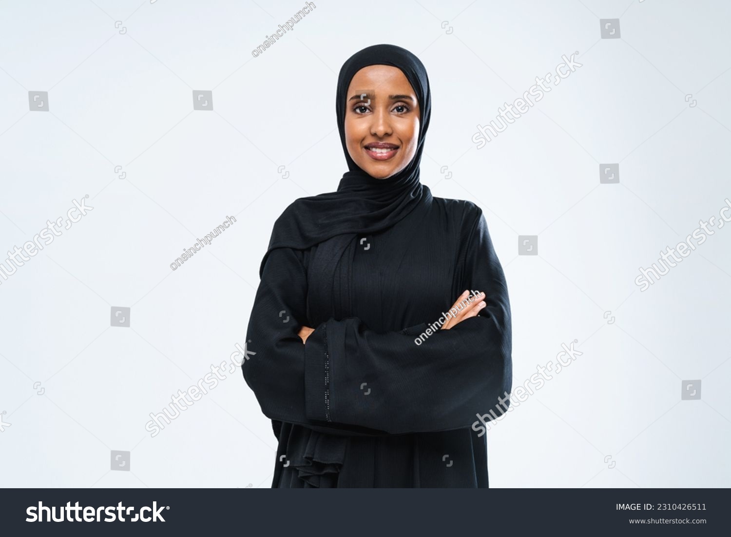 Beautiful arab middle-eastern woman with traditional abaya dress in studio - Arabic muslim adult female portrait in Dubai, United Arab Emirates #2310426511