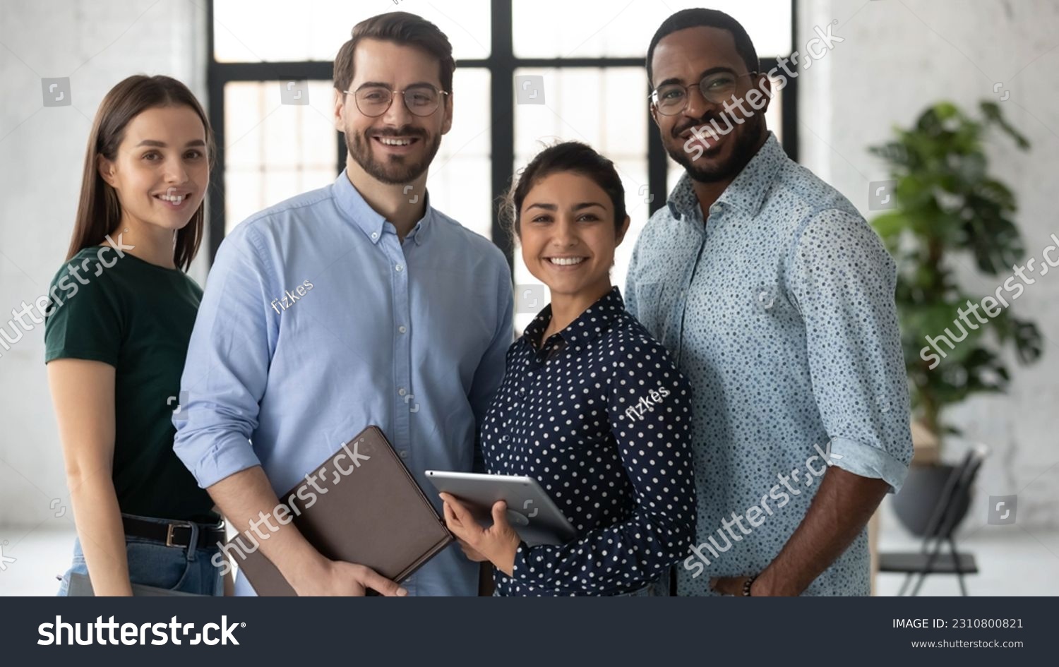 Group portrait of happy multiethnic united millennial team in modern office. Successful employees standing together, meeting in workspace, looking at camera and smiling Team work concept. Head shot #2310800821